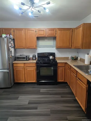 a kitchen with stainless steel appliances a stove a sink and a refrigerator