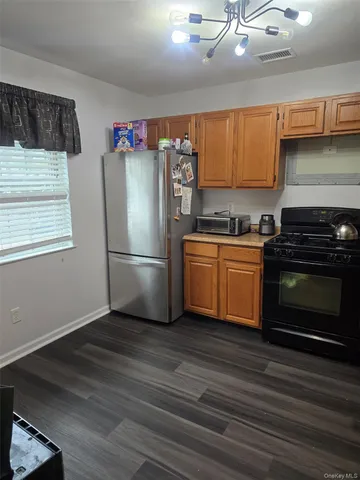 a kitchen with granite countertop a refrigerator stove top oven a sink and dishwasher