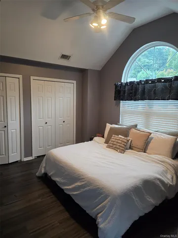 a bedroom with a bed and a wooden floor