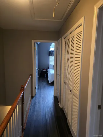 a view of a hallway with wooden floor and closet