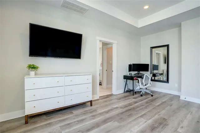 a view of a livingroom with a flat screen tv a piano and wooden floor