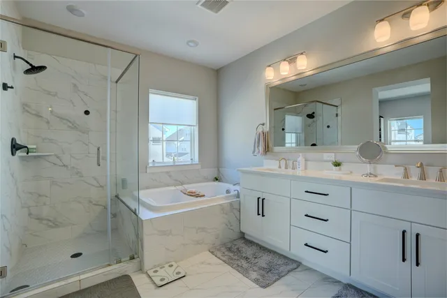 a bathroom with a double vanity sink toilet mirror and bathtub