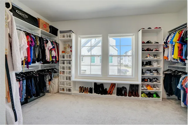 a view of walk in closet with clothes and shoes