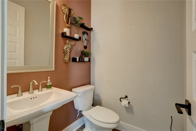 a bathroom with a sink mirror and toilet