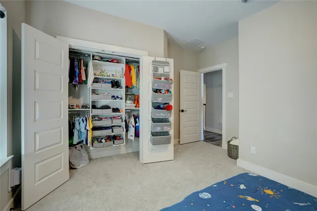 a bedroom with a bed and a flat tv screen on dresser