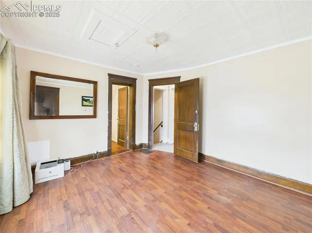 a view of an empty room with wooden floor