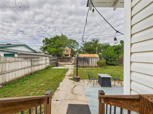 a view of backyard with seating area and trees in the background
