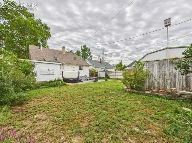 a yellow house sitting in the middle of a yard