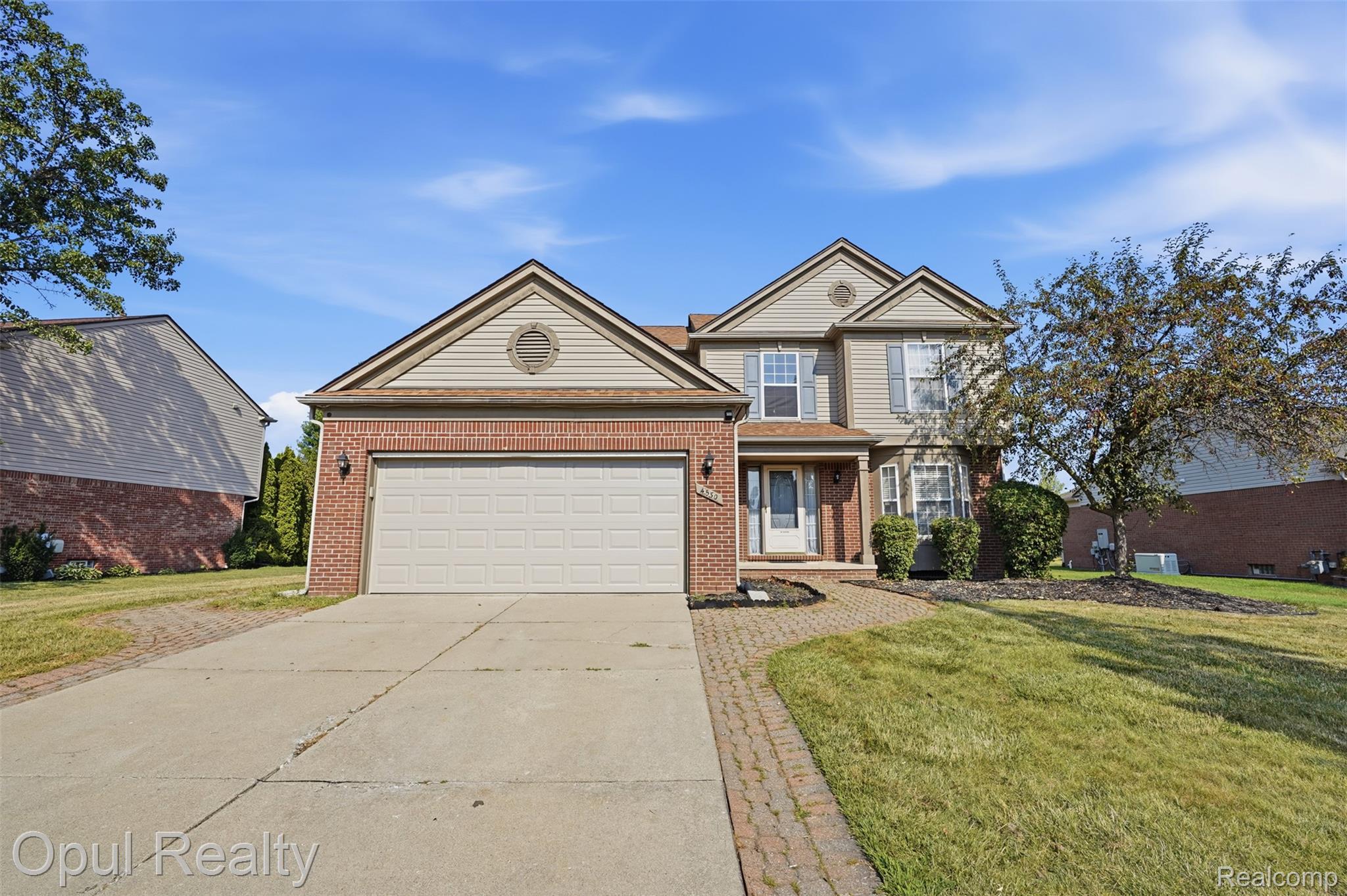 4530 Pond Run Canton, MI 48188 - Photo 1 of 43 Two-story residence featuring a brick and siding exterior, an attached two-car garage, concrete driveway, and a paver stone walkway