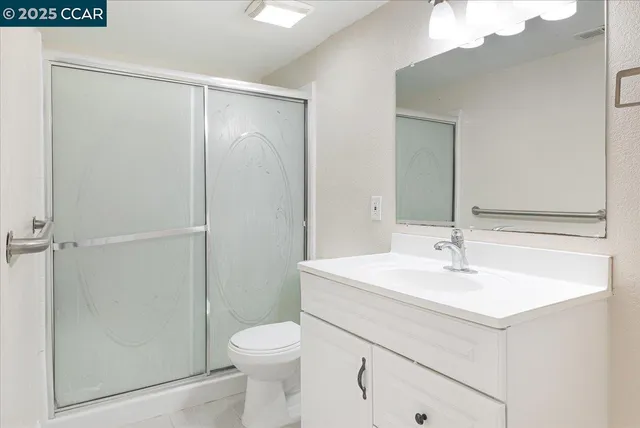 a bathroom with a sink toilet vanity and shower