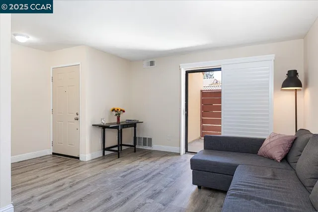 a living room with furniture a wooden floor and a window