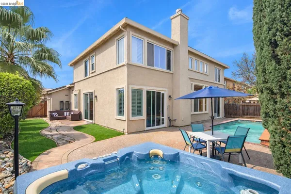 a patio with a table and chairs under an umbrella