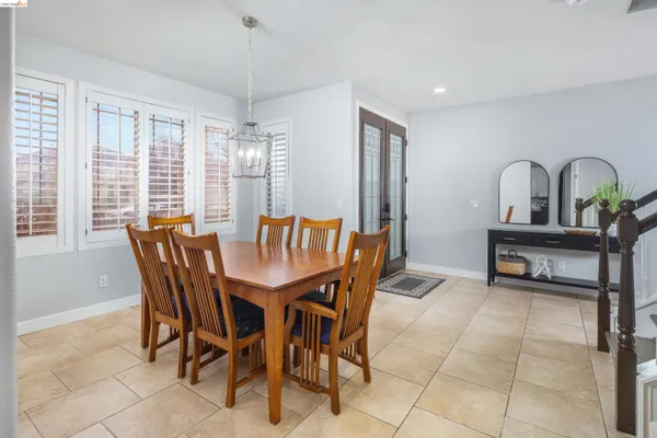 a dining room with furniture a chandelier and wooden floor