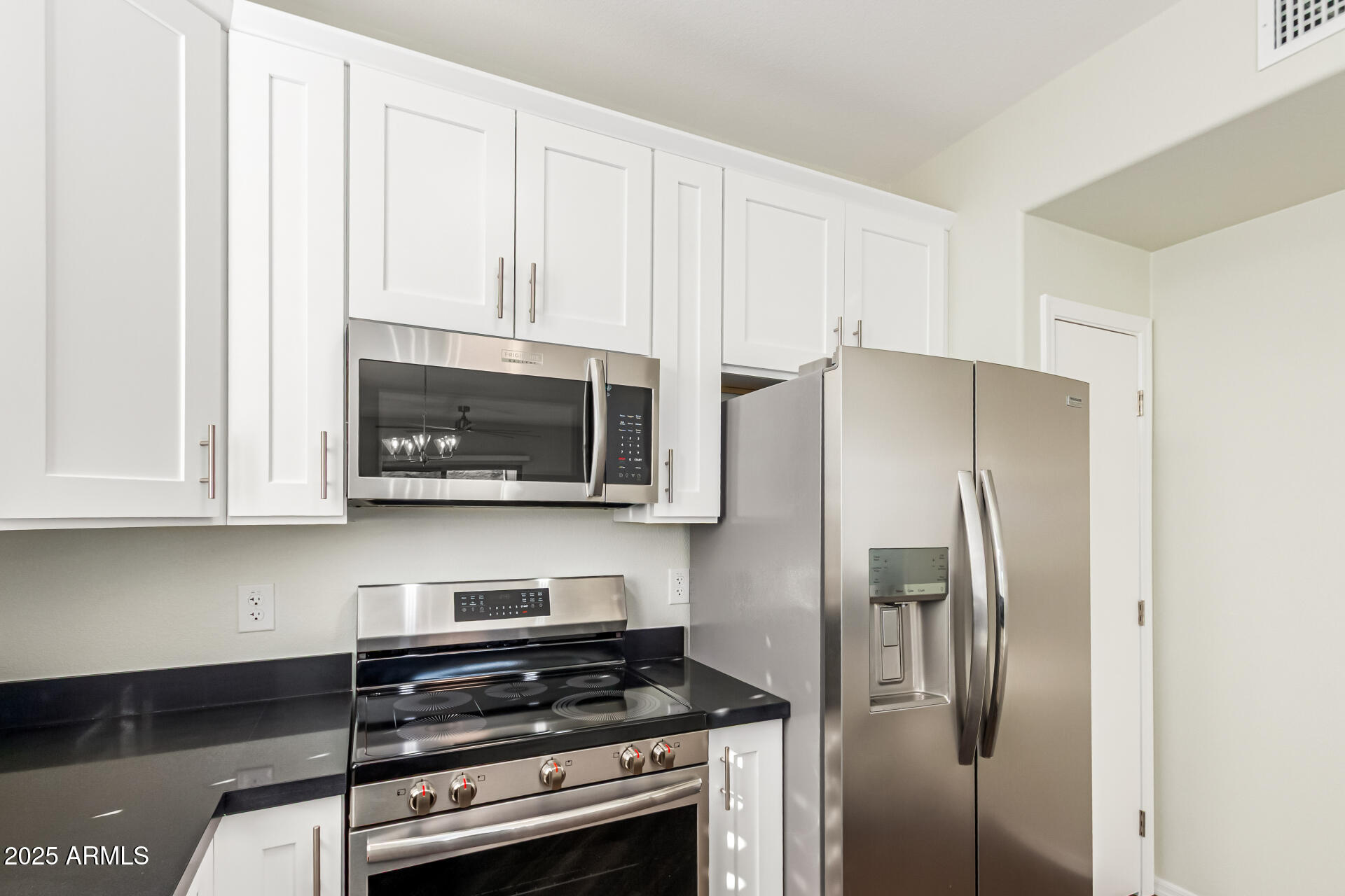 1720 East Thunderbird Road, Unit 2125 Phoenix, AZ 85022 - Photo 14 of 37 a kitchen with stainless steel appliances white cabinets and a stove top oven