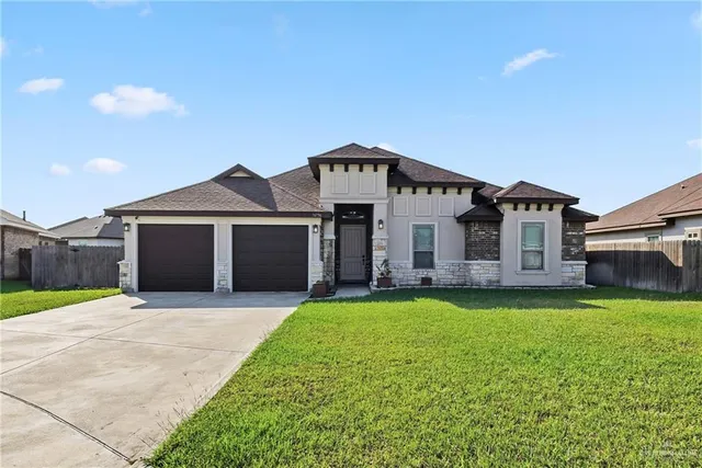 a front view of a house with a yard and garage