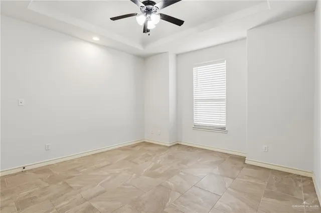 an empty room with a window and a fan