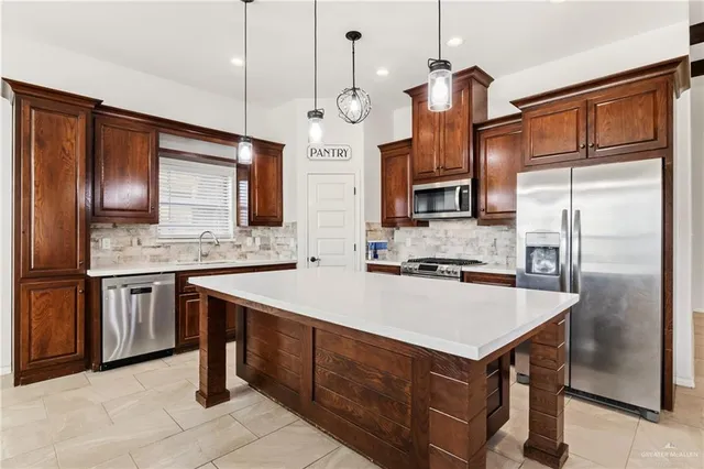 a kitchen with a refrigerator a sink and a microwave