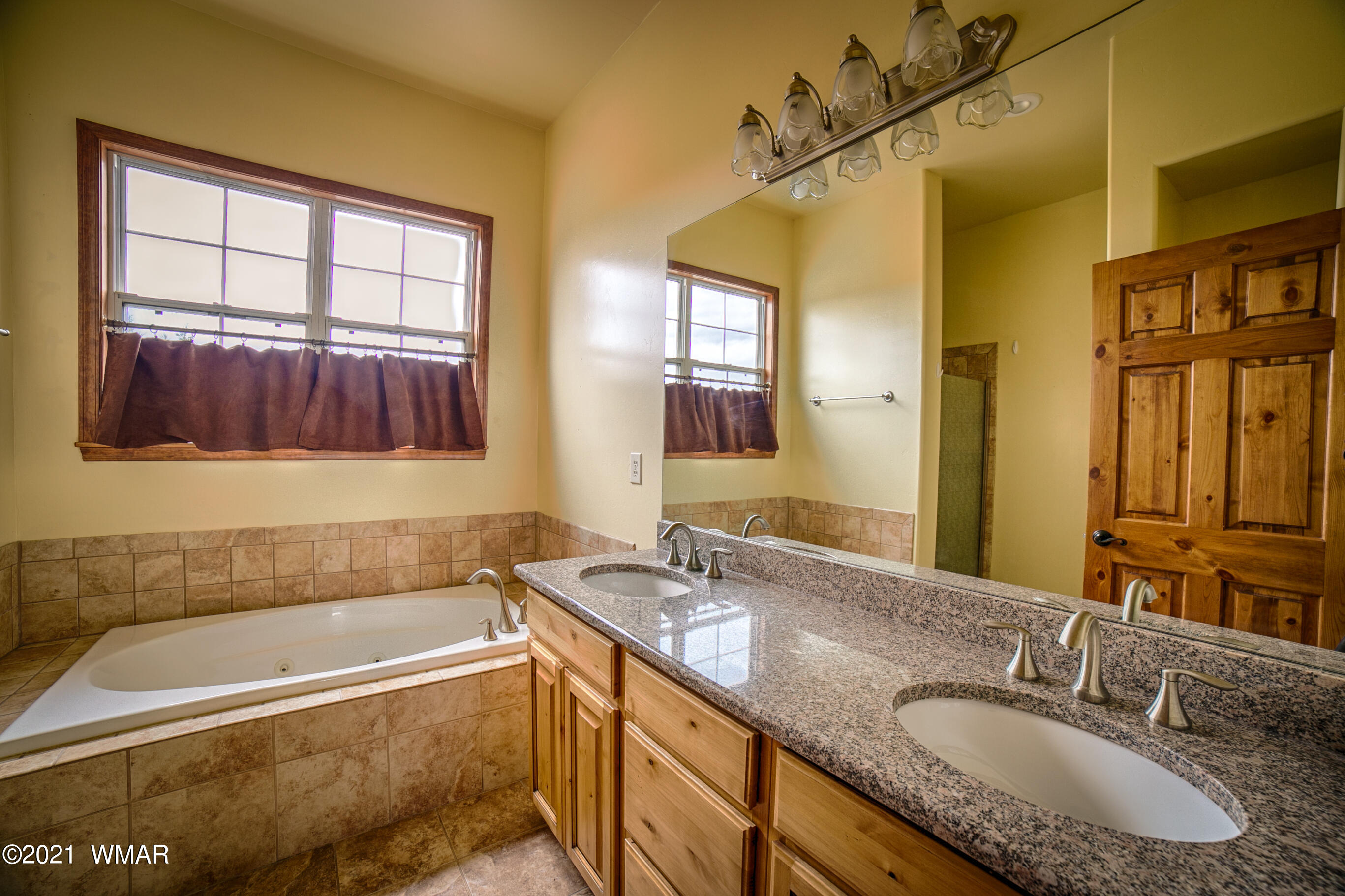 600 South Rock Ridge Drive Show Low, AZ 85901 - Photo 21 of 25 a bathroom with a granite countertop tub sink and mirror