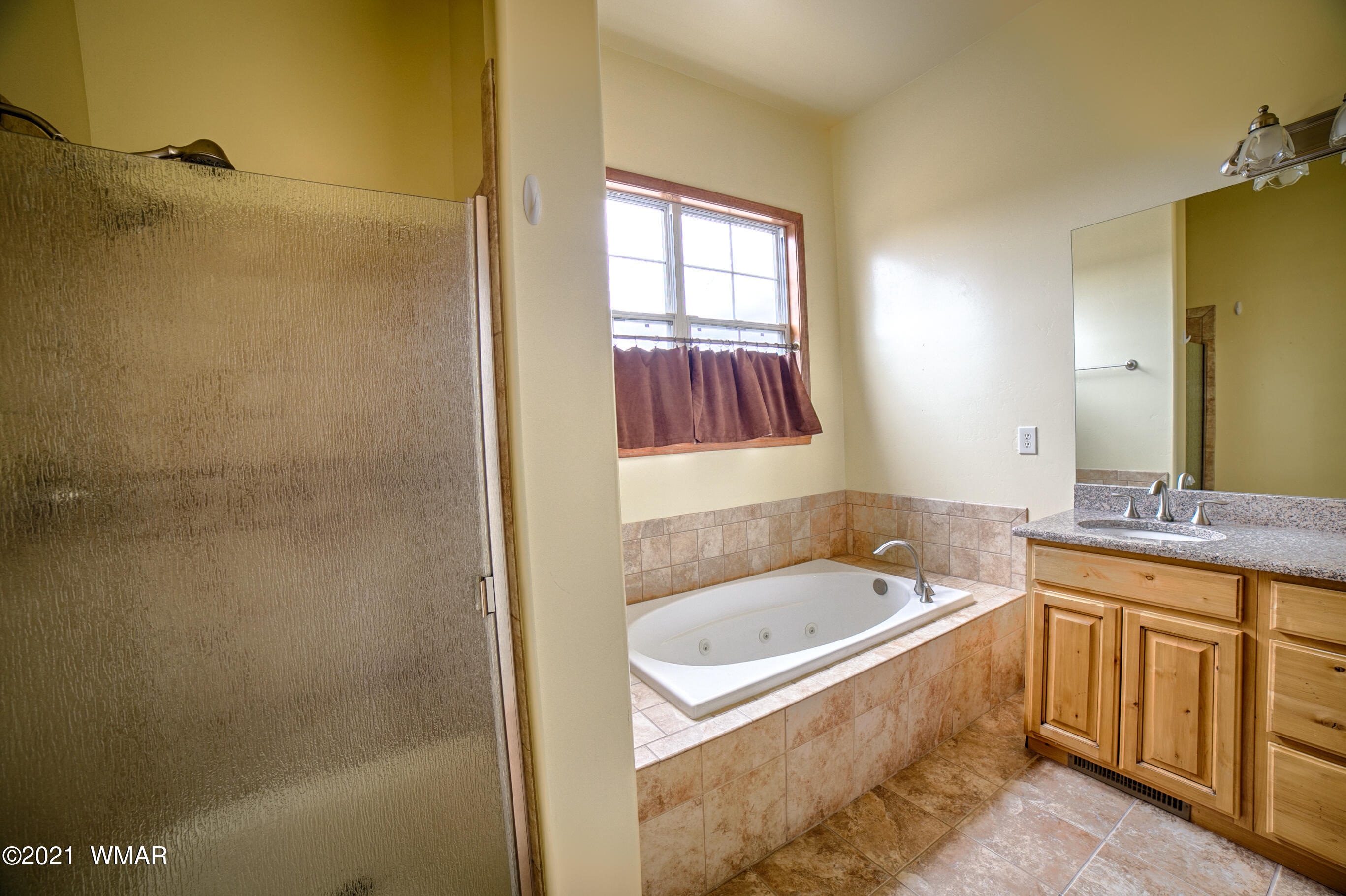 600 South Rock Ridge Drive Show Low, AZ 85901 - Photo 22 of 25 a bathroom with a tub a sink and a window