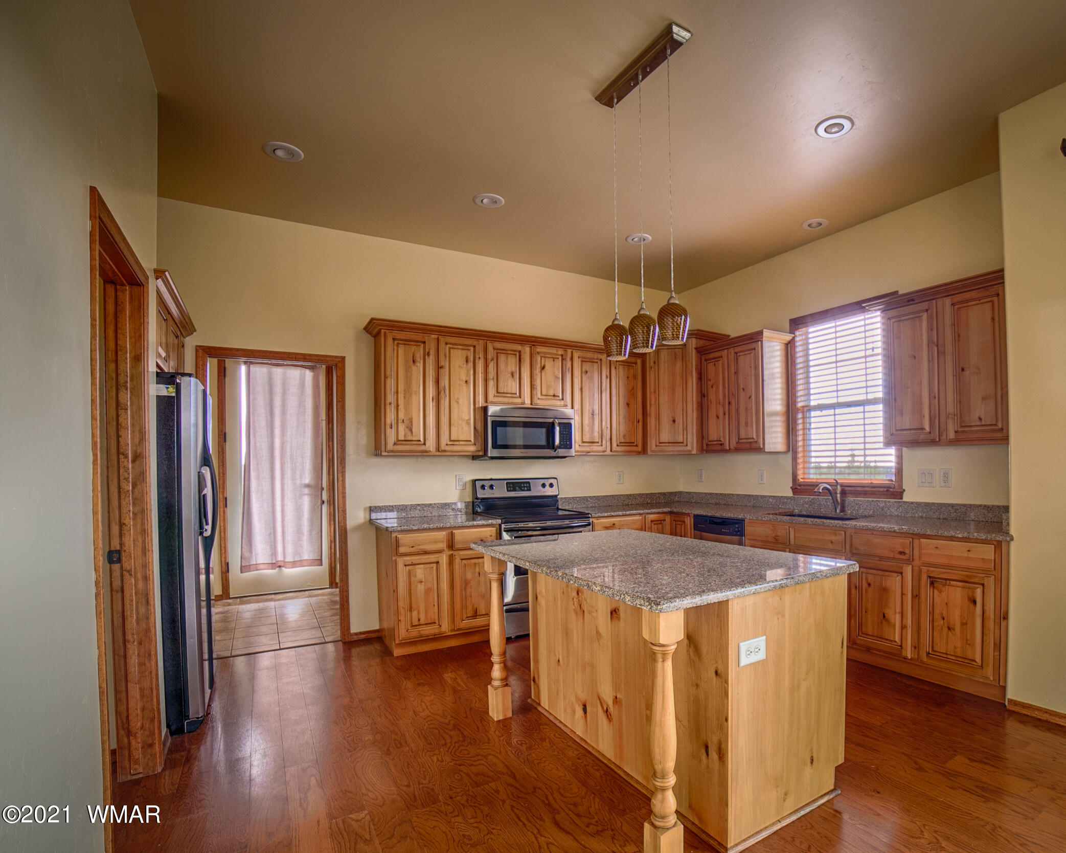 600 South Rock Ridge Drive Show Low, AZ 85901 - Photo 9 of 25 a kitchen with stainless steel appliances granite countertop a stove top oven a refrigerator a sink and dishwasher with wooden floor