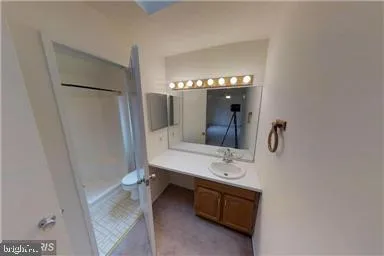a white toilet sitting in a bathroom next to a window