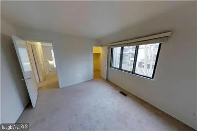 a view of a livingroom with an empty space and a window