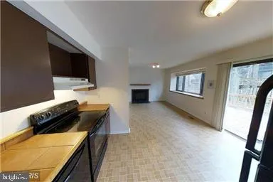 a kitchen with a stove and a flat screen tv