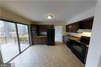 a kitchen with granite countertop a refrigerator and a stove top oven