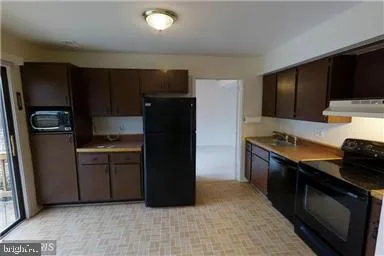a kitchen with stainless steel appliances granite countertop a refrigerator and a stove