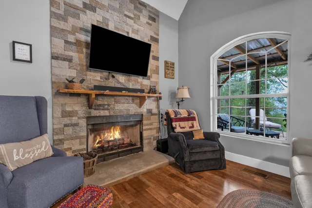 a living room with furniture a flat screen tv and a fireplace