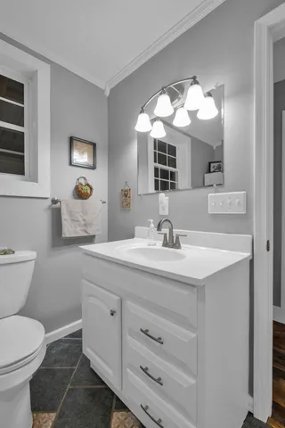 a bathroom with a toilet sink and mirror