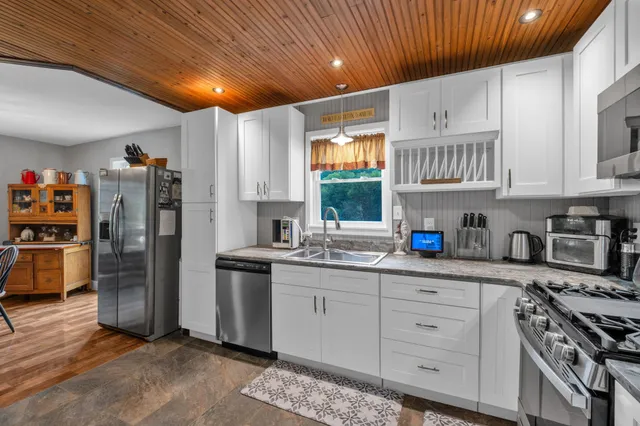 a kitchen with stainless steel appliances granite countertop a refrigerator and a sink