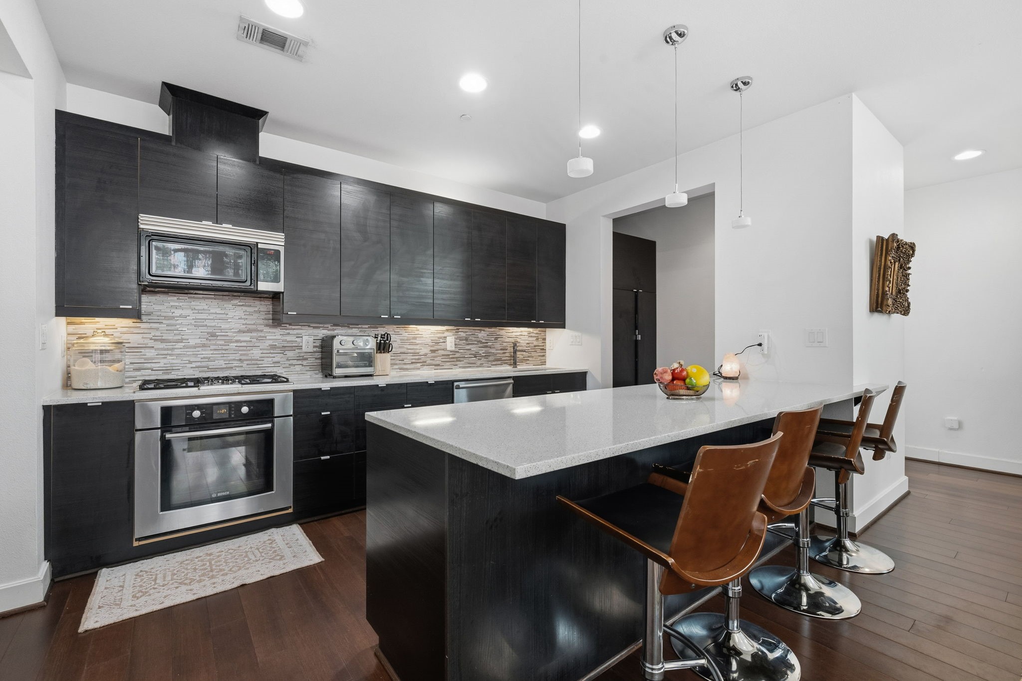 3302 Lake Street, Unit 3 Houston, TX 77098 - Photo 7 of 20 a kitchen with stainless steel appliances kitchen island granite countertop a stove a refrigerator a sink a dining table and chairs with wooden floor