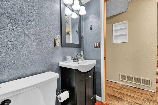 a bathroom with a sink and mirror with toilet