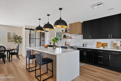 a kitchen with a sink cabinets and wooden floor