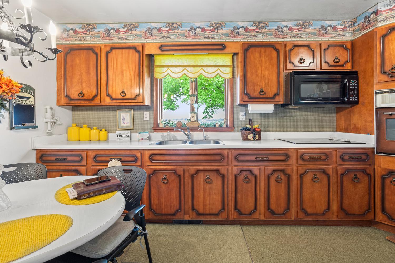 4520 North 600 East Road Sidell, IL 61876 - Photo 10 of 31 a kitchen with a sink a stove and a dining table with chairs