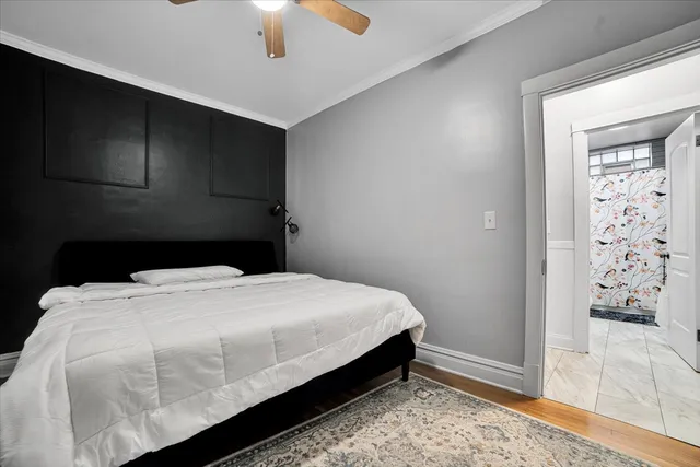 a large bed sitting in a bedroom next to a window and a chandelier