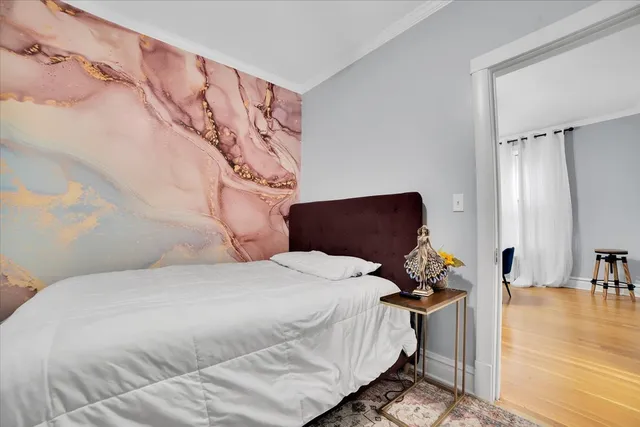 a bedroom with a bed and wooden floor