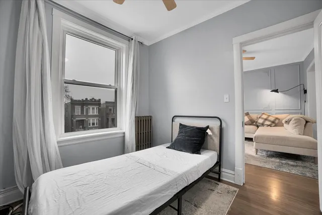 a bedroom with a bed and wooden floor