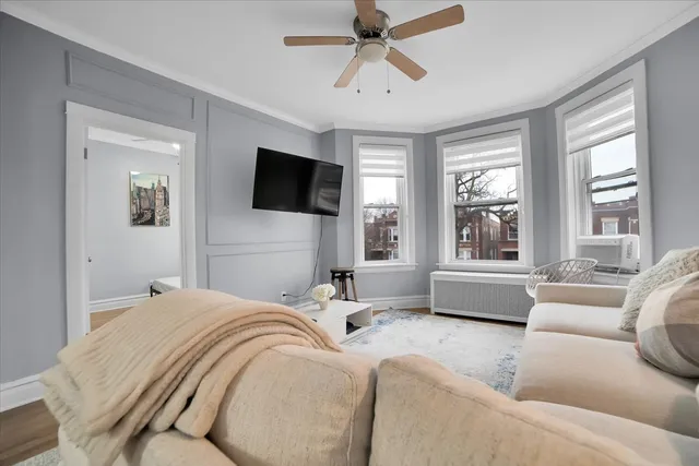 a bedroom with a bed a couch and a flat screen tv