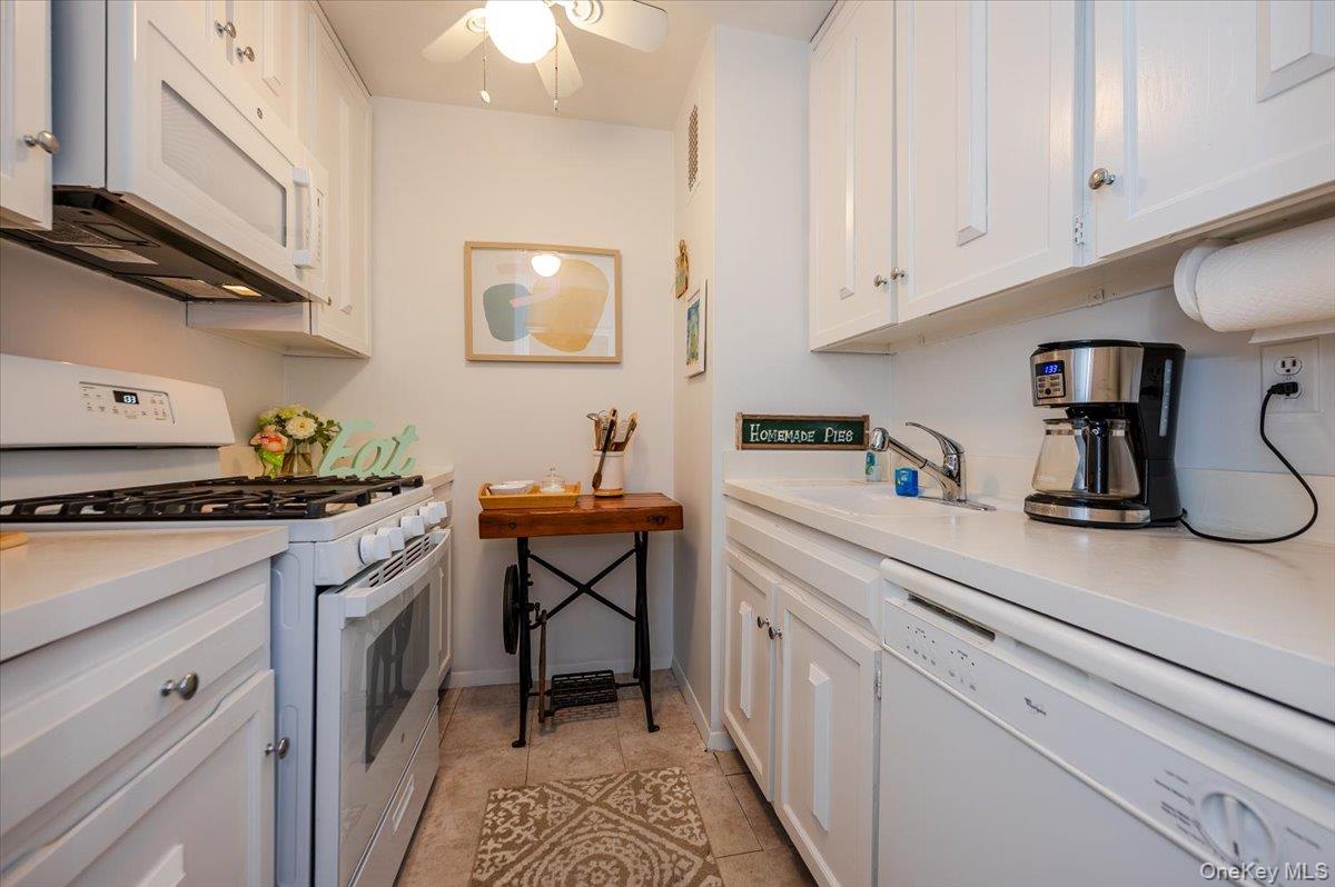 650 Shore Road, Unit 5P Long Beach, NY 11561 - Photo 9 of 29 Kitchen with white appliances and white cabinetry
