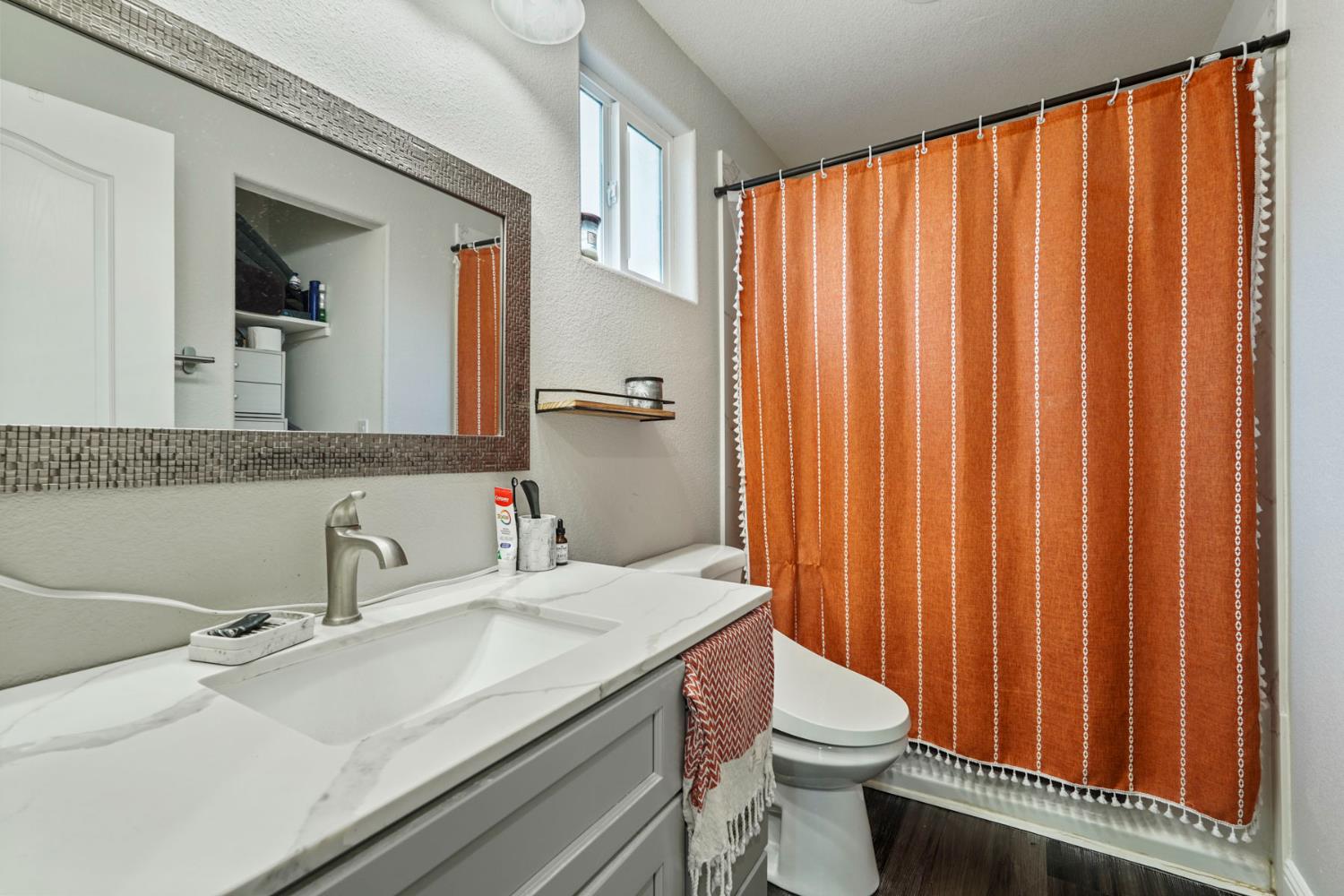223 Rush Street Lodi, CA 95240 - Photo 14 of 21 a bathroom with a sink a toilet and shower curtain