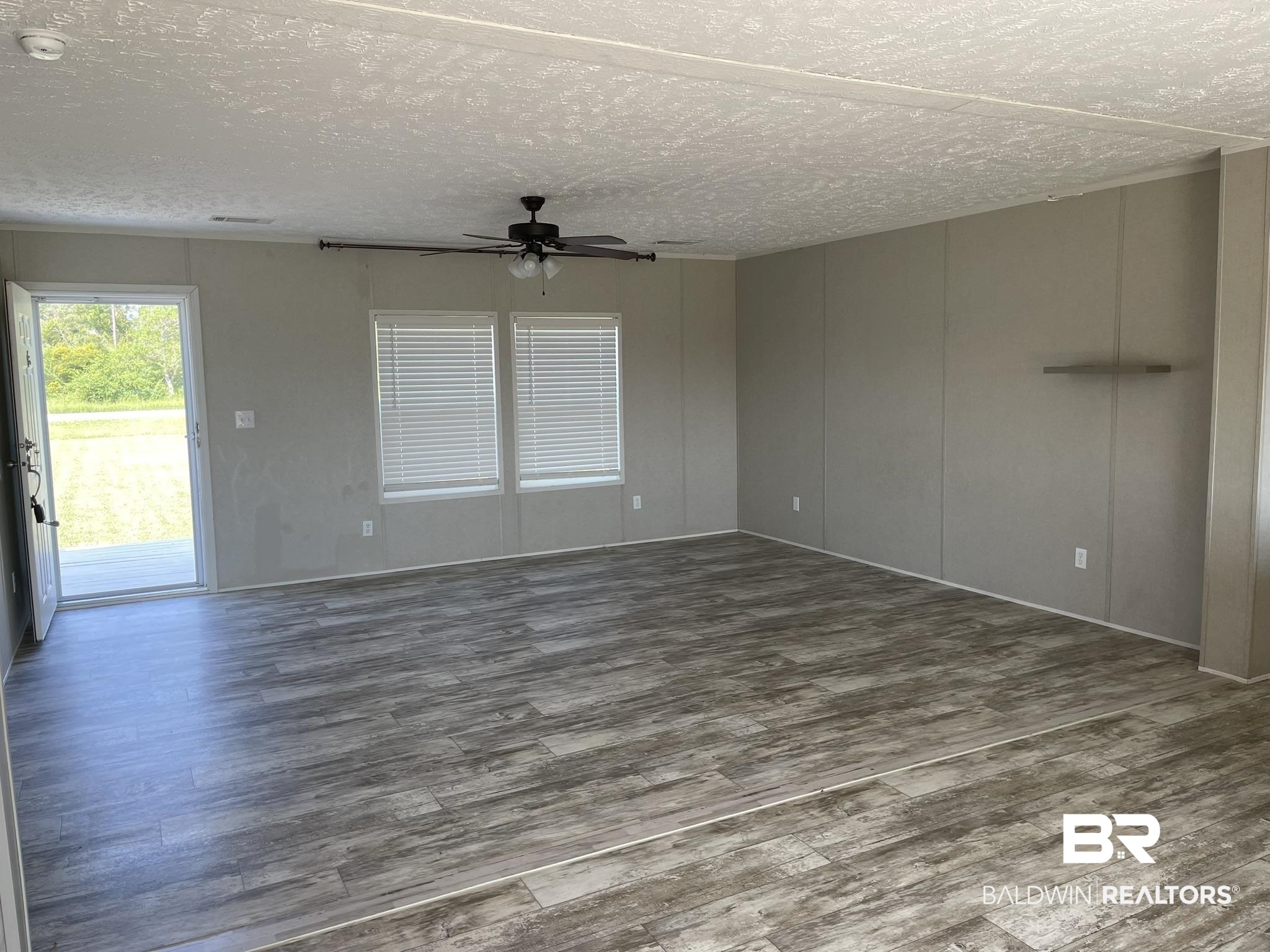 16802 County Road 87 Elberta, AL 36530 - Photo 4 of 19 Unfurnished living room with wood finished floors, a ceiling fan, and a textured ceiling