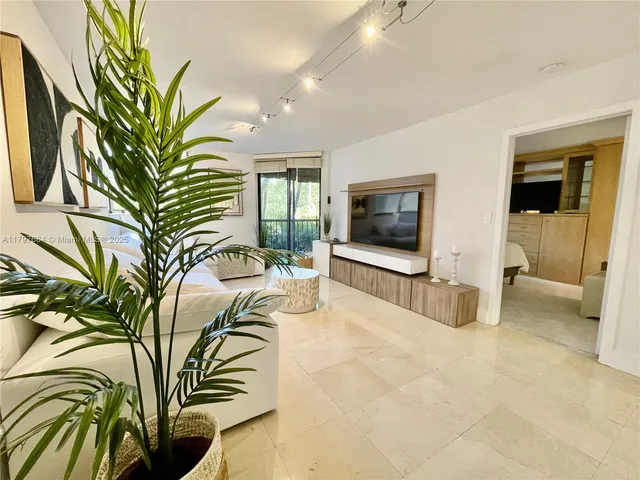 a view of a bedroom with a bed and a flat screen tv