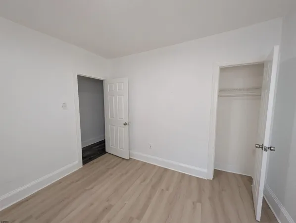 an empty room with wooden floor and closet