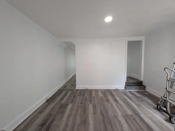 a view of a room with wooden floor and a sink
