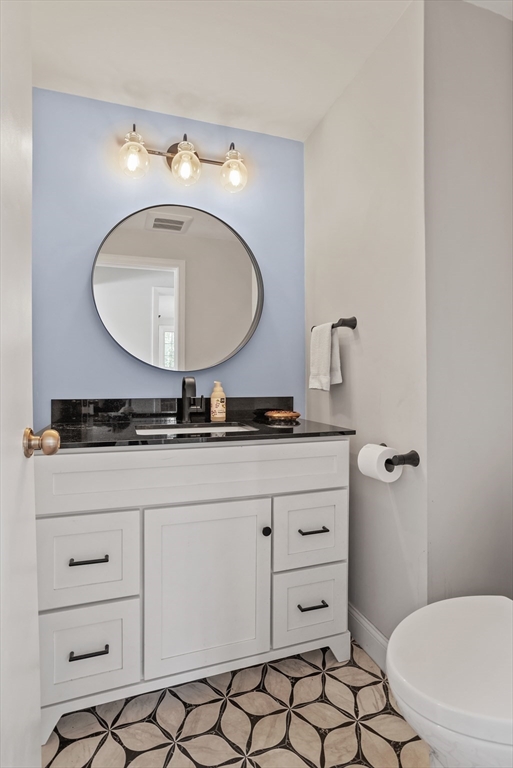 66 Old Stow Road Concord, MA 01742 - Photo 16 of 42 a bathroom with a granite countertop toilet sink and mirror