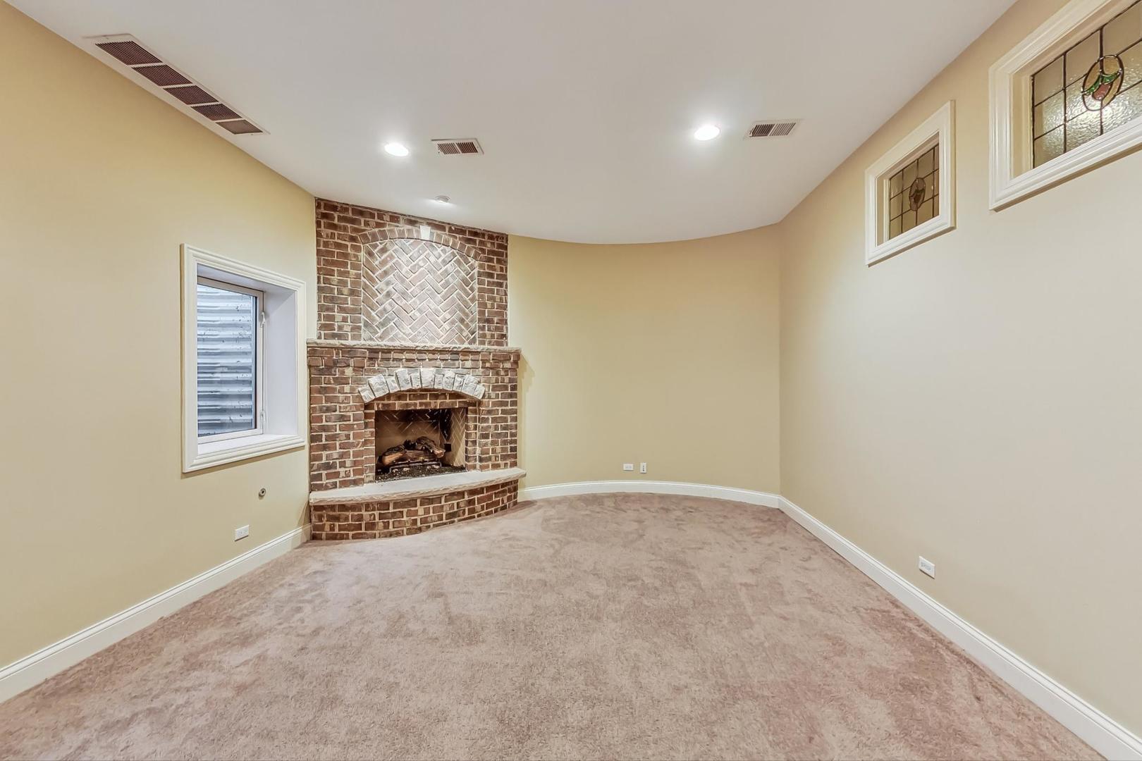 136 Fuller Road Hinsdale, IL 60521 - Photo 39 of 53 a view of an empty room with a fireplace and a window