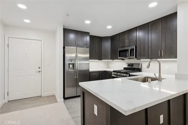 a kitchen with a sink a counter space cabinets and stainless steel appliances