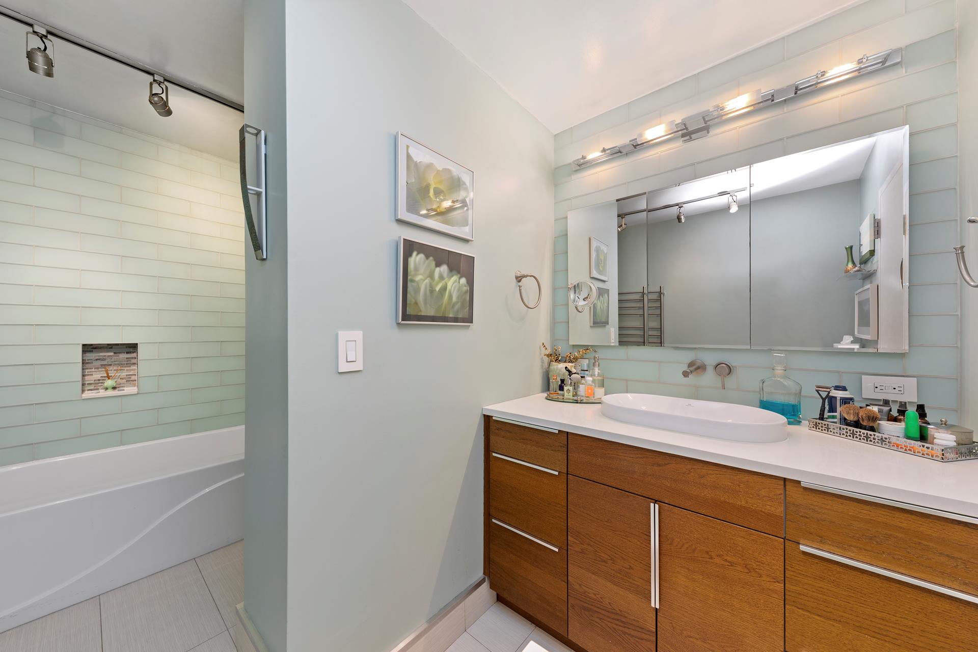 137 East 36th Street, Unit 5B Manhattan, NY 10016 - Photo 21 of 30 a bathroom with a double vanity sink mirror and shower
